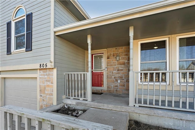 entrance to property featuring covered porch and a garage