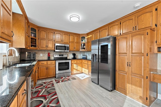 kitchen featuring tasteful backsplash, appliances with stainless steel finishes, sink, and dark stone counters