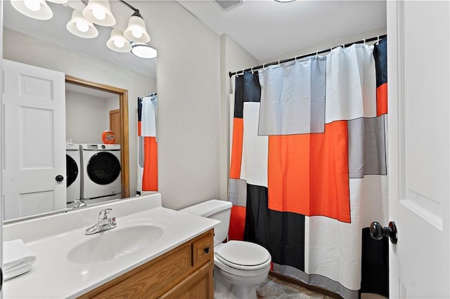 bathroom featuring washing machine and dryer, walk in shower, vanity, and toilet