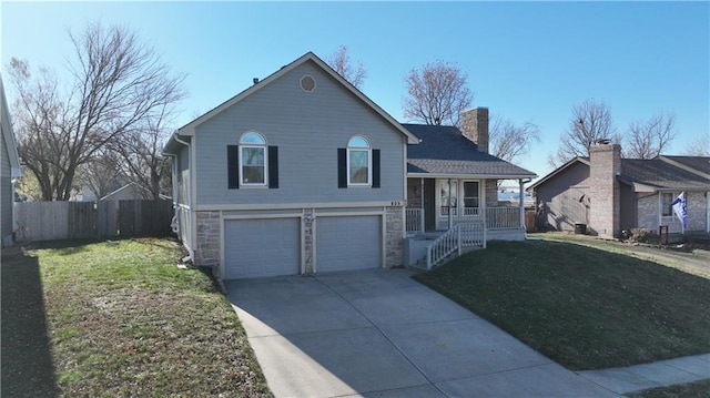 split level home featuring a porch, a garage, and a front yard