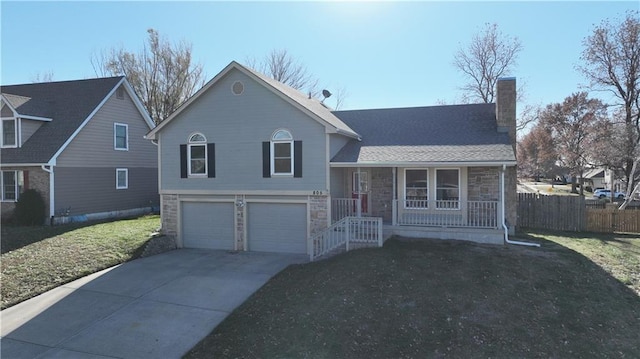 split level home with a porch, a garage, and a front yard