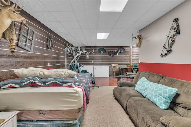 living room with a paneled ceiling and wood walls