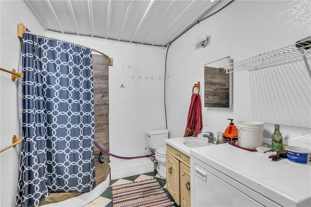 bathroom with vanity, toilet, curtained shower, and concrete floors