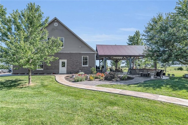 back of property featuring a gazebo and a lawn