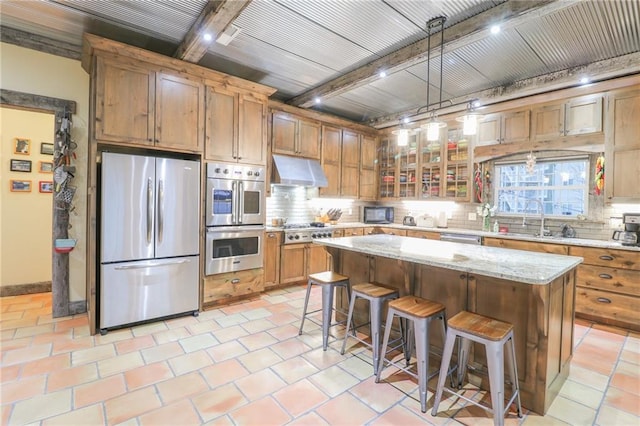 kitchen with beamed ceiling, decorative light fixtures, a kitchen island, and stainless steel appliances