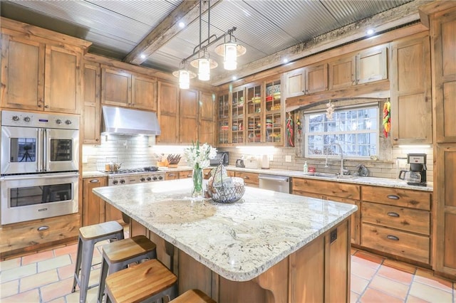 kitchen with decorative light fixtures, a center island, a kitchen breakfast bar, and appliances with stainless steel finishes