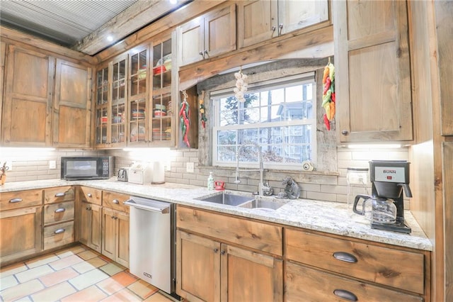 kitchen featuring dishwasher, backsplash, sink, light stone countertops, and light tile patterned floors