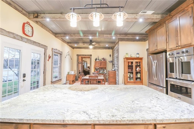 kitchen with a center island, hanging light fixtures, ceiling fan, beam ceiling, and stainless steel appliances