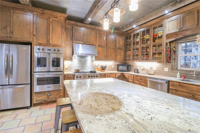 kitchen featuring pendant lighting, sink, beamed ceiling, a kitchen bar, and stainless steel appliances