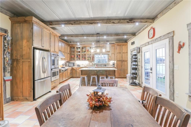 dining area featuring beam ceiling, light tile patterned floors, and french doors