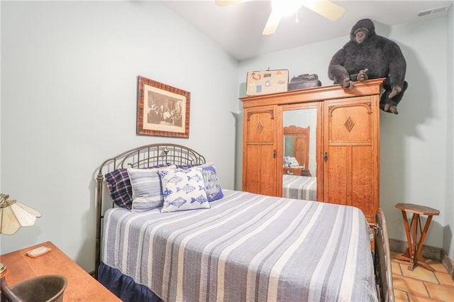 tiled bedroom featuring ceiling fan