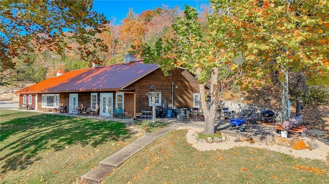 back of house featuring french doors, a patio, and a lawn