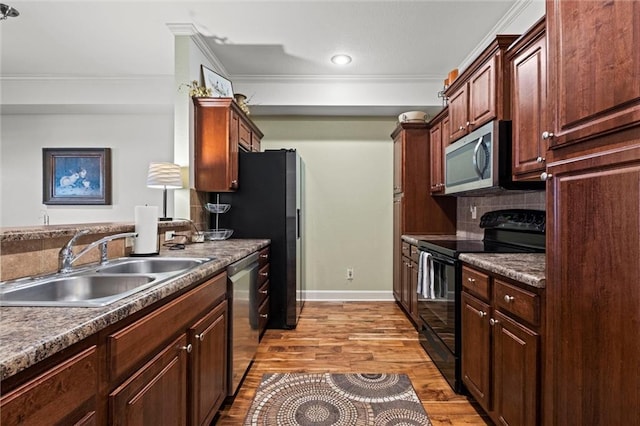 kitchen featuring appliances with stainless steel finishes, light wood-type flooring, crown molding, and sink