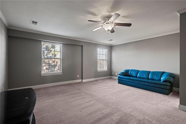 sitting room featuring ornamental molding, carpet floors, ceiling fan, and a healthy amount of sunlight