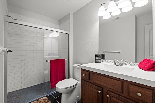 bathroom with tile patterned floors, vanity, toilet, and a shower with shower door