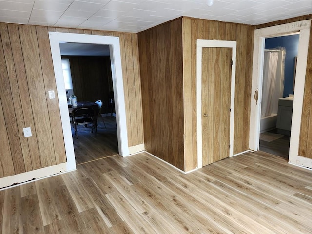 interior space with hardwood / wood-style flooring and wooden walls