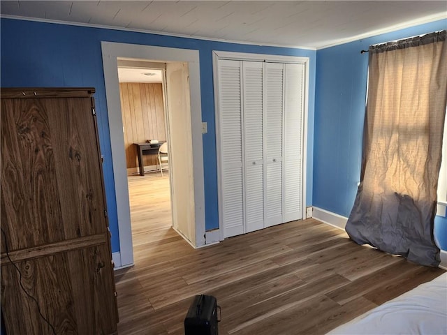 bedroom featuring dark hardwood / wood-style flooring, a closet, and crown molding