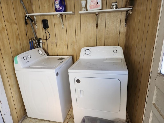 laundry room featuring washer and clothes dryer and wood walls