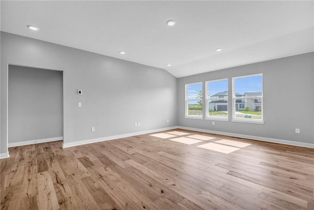 unfurnished room featuring lofted ceiling, recessed lighting, light wood-type flooring, and baseboards