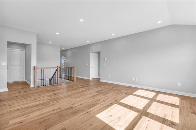 unfurnished room with baseboards, vaulted ceiling, recessed lighting, and light wood-style floors