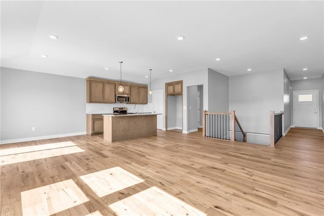 unfurnished living room featuring baseboards, recessed lighting, and light wood-style floors