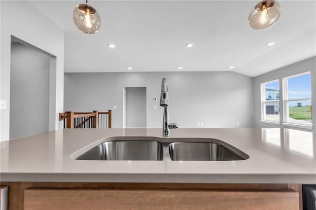 kitchen with recessed lighting, a sink, vaulted ceiling, light countertops, and hanging light fixtures