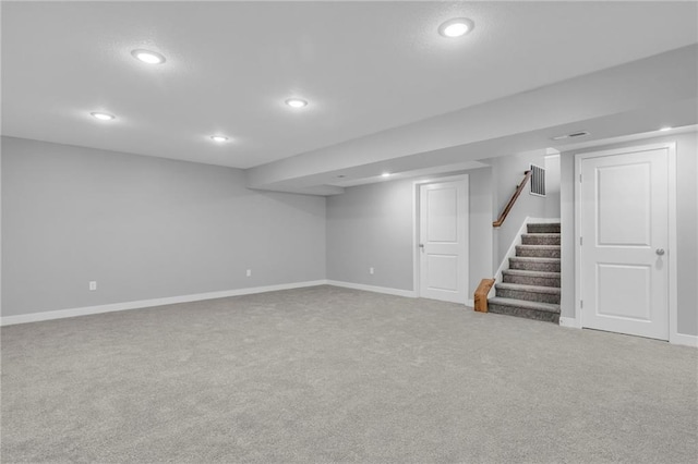 finished below grade area with recessed lighting, carpet flooring, stairway, and baseboards