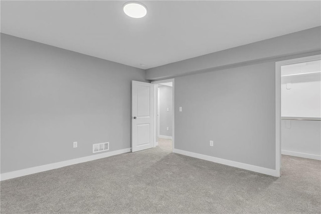 carpeted spare room featuring visible vents and baseboards