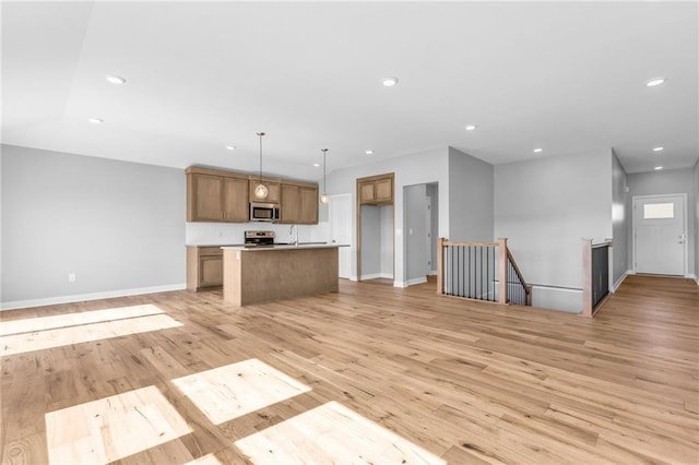 17756 Houston St, Gardner, KS 66030 - kitchen with appliances with stainless steel finishes, open floor plan, recessed lighting, an island with sink, and light wood finished floors