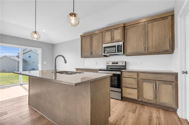 17756 Houston St, Gardner, KS 66030 - kitchen with stainless steel appliances, decorative backsplash, light wood-type flooring, and an island with sink