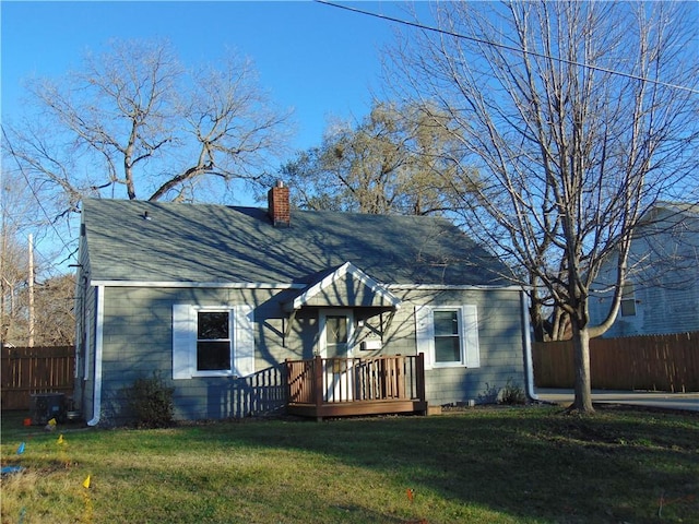 view of front of house featuring central air condition unit, a front lawn, and a deck