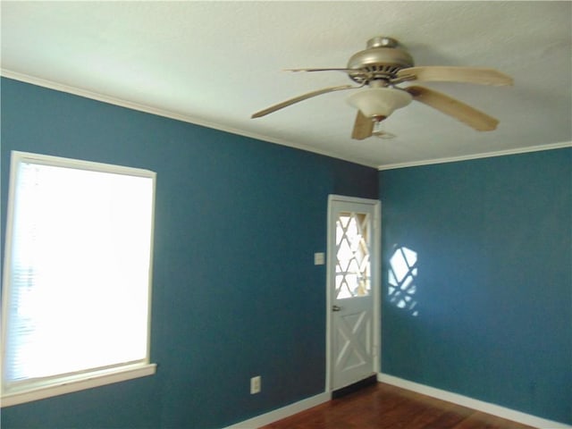 empty room featuring ornamental molding, ceiling fan, and dark wood-type flooring