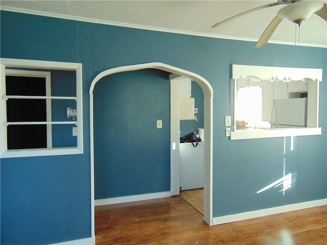 unfurnished room featuring ceiling fan, wood-type flooring, and ornamental molding