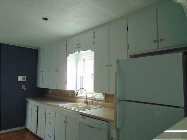 kitchen with white cabinetry, white appliances, sink, and tasteful backsplash