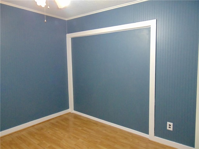 empty room with hardwood / wood-style flooring, ceiling fan, and crown molding