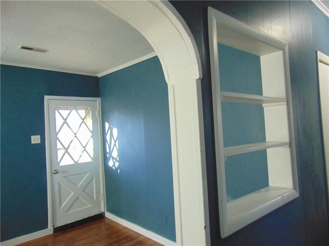 entryway featuring crown molding and dark wood-type flooring