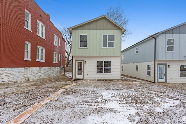 snow covered house with board and batten siding