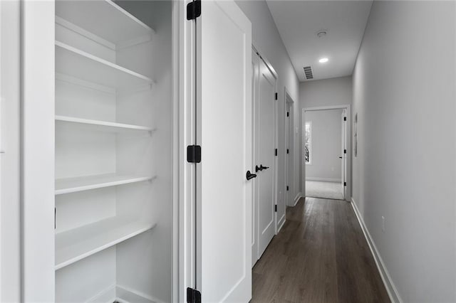 corridor with visible vents, dark wood finished floors, and baseboards