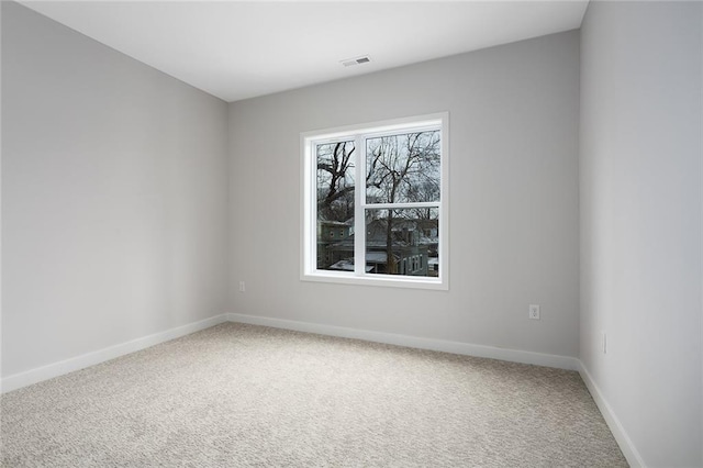 carpeted empty room featuring visible vents and baseboards