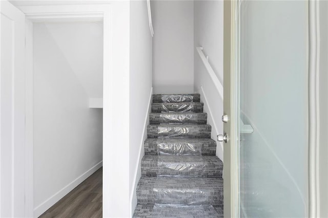 stairway with wood finished floors and baseboards