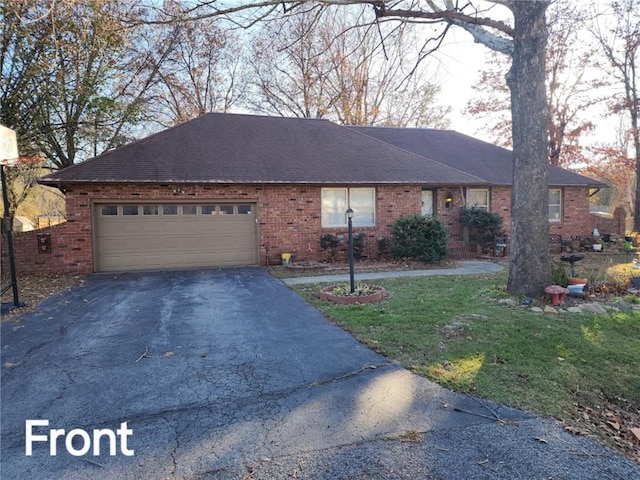 ranch-style home with a front lawn and a garage