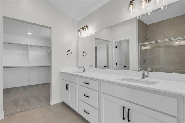 bathroom with a shower with door, vanity, and tile patterned flooring