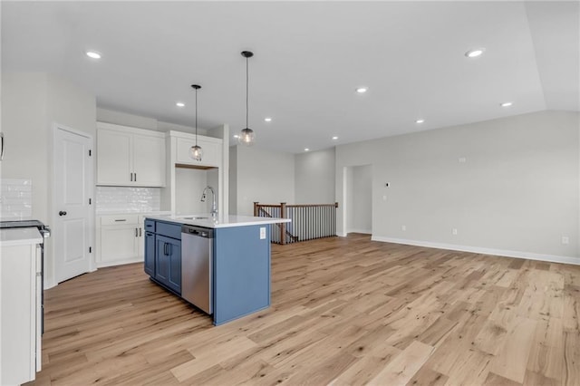 kitchen featuring dishwasher, white cabinetry, hanging light fixtures, an island with sink, and blue cabinets