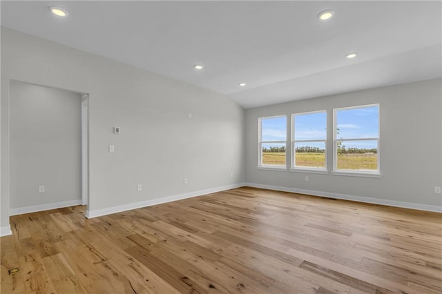 empty room featuring lofted ceiling and light hardwood / wood-style floors