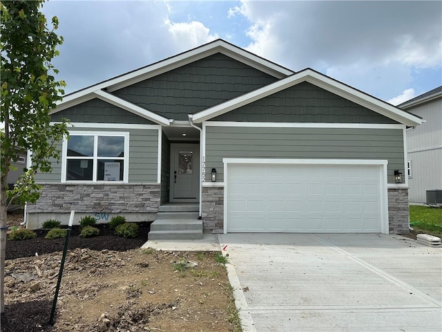 17752 Houston St, Gardner, KS 66030 - view of front of house with stone siding, concrete driveway, and an attached garage