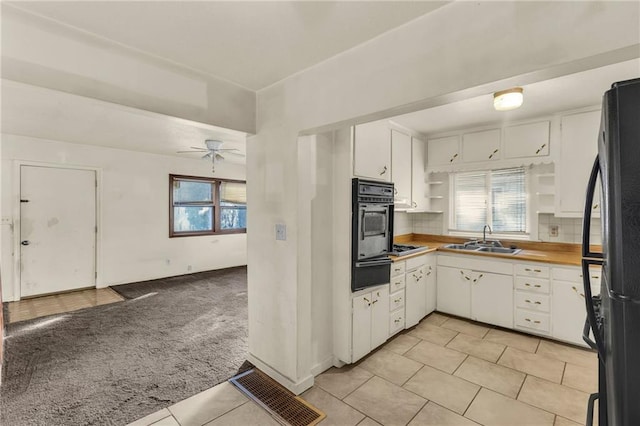 kitchen with tasteful backsplash, ceiling fan, sink, black appliances, and white cabinetry