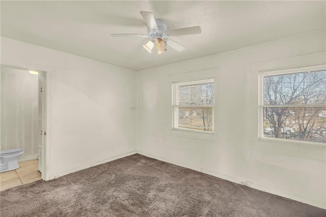 carpeted empty room featuring a textured ceiling and ceiling fan