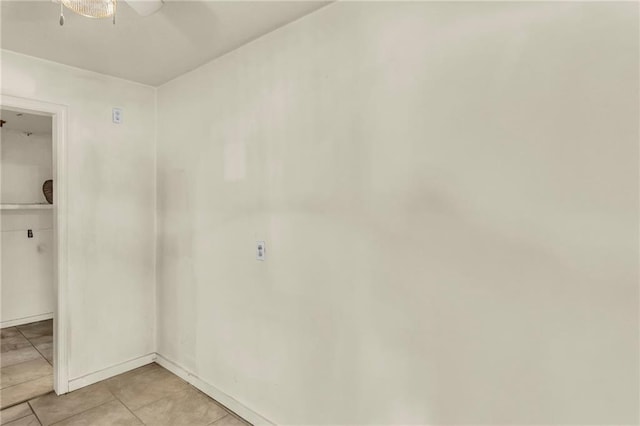 empty room featuring ceiling fan and light tile patterned floors