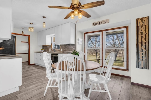 dining space featuring ceiling fan, sink, and light hardwood / wood-style flooring