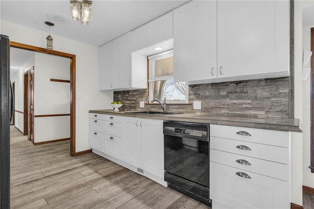 kitchen featuring decorative backsplash, sink, light hardwood / wood-style flooring, white cabinets, and black dishwasher